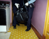 Officers transport body of deceased 83 year-old man found in bathroom of his home, Chicago, Illinois, 2000