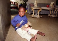 Lee Lee White with doll in doorway of grandmother’s apartment in Stateway Gardens housing project before evacuation, Chicago, Illinois, 2000  thumbnail
