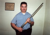Special operations officer displays firearm confiscated from gang members in housing project, Chicago, Illinois, 2000 thumbnail