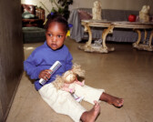 Lee Lee White with doll in doorway of grandmother's apartment in Stateway Gardens housing project before evacuation, Chicago, Illinois, 2000